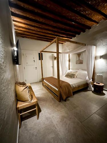a bedroom with a canopy bed and a chair at Kisari Kimolos Cozy Studio in Kimolos