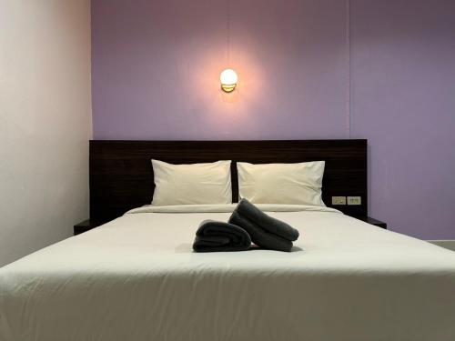 a bedroom with a bed with a hat on it at Hatyai Bangkok Resort หาดใหญ่ บางกอก รีสอร์ท in Hat Yai