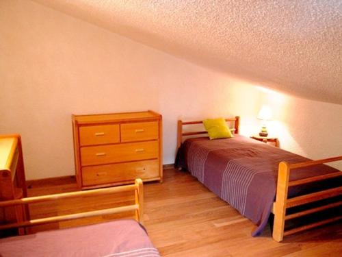 une chambre avec un lit et une commode dans l'établissement Appartement F3 confortable proche des pistes, idéal familles - FR-1-814-46, à Besse-et-Saint-Anastaise