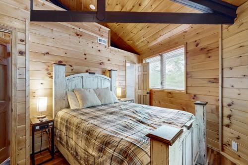 a bedroom with a bed in a wooden cabin at Slopesider 20A in Sugar Mountain