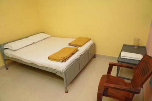 a small bedroom with a bed and a chair at AJ GrandInn in Podanūr