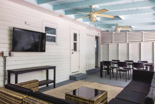 a living room with a television and a table and chairs at Coconut Palm in Key West