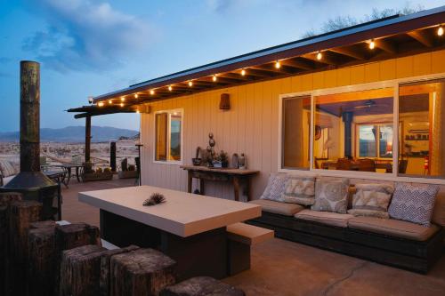 a patio with a couch and a table on a house at Twentynine Palms Desert Oasis with Pool and Hot Tub! in Twentynine Palms