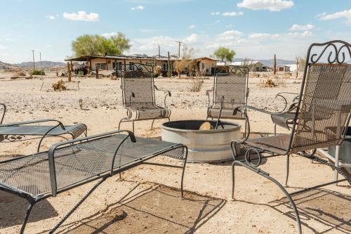 a group of chairs and a fire pit in the desert at Twentynine Palms Desert Oasis with Pool and Hot Tub! in Twentynine Palms