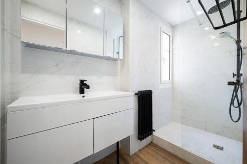 une salle de bain blanche avec un lavabo et une douche dans l'établissement Appartement F4, 3 chambres, 76 m2, à Nice