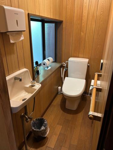 a bathroom with a toilet and a sink and a mirror at Kominkayado Gon in Tamano