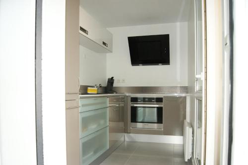 Il comprend une cuisine équipée d'appareils en acier inoxydable et une télévision à écran plat. dans l'établissement Appart'Hôtel Saint Exupery, à Besançon