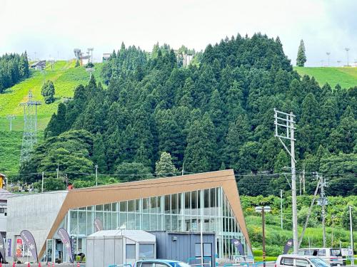 a large building with cars parked in front of a mountain at 越後湯沢石打Nozomi ski in ski out in Minami Uonuma