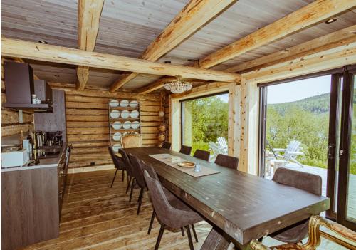 a dining room and kitchen in a log cabin with a table and chairs at Stabburet Madam Meyer in Skage i Namdalen