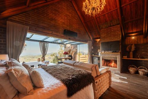 a bedroom with a fireplace and a bed with a couch at Morada Valente in Gramado