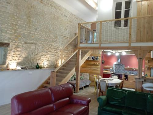 a living room with a staircase and a table at La grange d'Isabelle in Rouillac