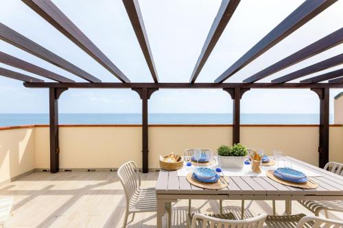 a dining room with a table and chairs and the ocean at Italian Experience-La Terrazza Sul Conero in Porto Recanati
