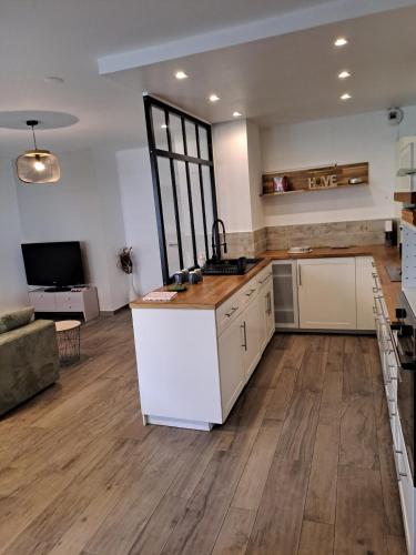 une grande cuisine avec des appareils blancs et du parquet dans l'établissement Appartement spacieux, à Villeneuve-Loubet