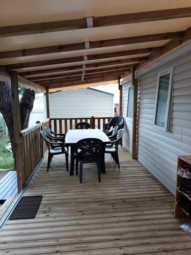 un patio avec une table et des chaises sur une terrasse dans l'établissement Bungalow familial à Canet-en-Roussillon avec piscine, à Canet