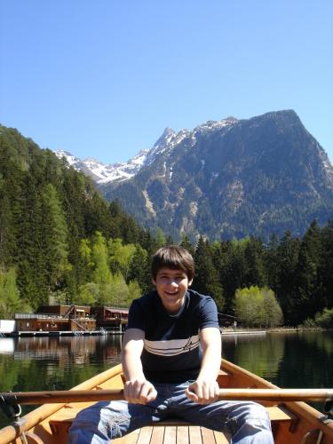 a man sitting in a boat on a lake at Appartement Schmid in Oetz