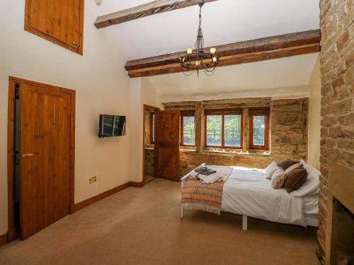 a bedroom with a bed and a stone wall at Pule Hill Farm in Huddersfield