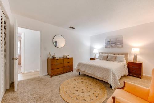a white bedroom with a bed and a mirror at Walk to Lake Munson Tree-Filled Tallahassee Gem! in Tallahassee