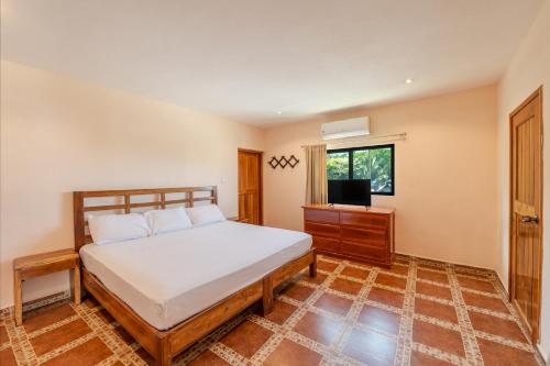 a bedroom with a bed and a television in it at Hotel El Perico Marinero in Río Lagartos