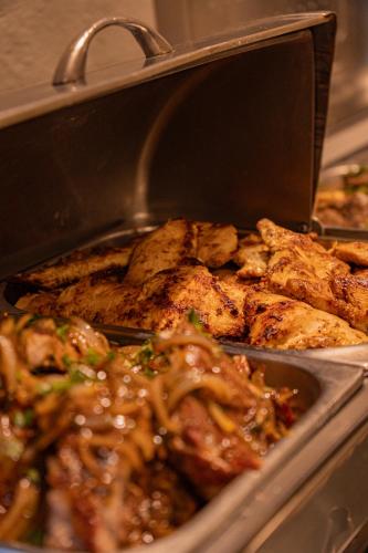 a pan filled with meat and other food at Hotel Porto Napolis in Eunápolis