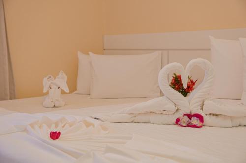 a white bed with two swans made out of towels at Hotel Porto Napolis in Eunápolis
