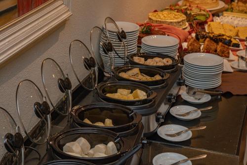 a buffet with plates and bowls of food on a table at Hotel Porto Napolis in Eunápolis