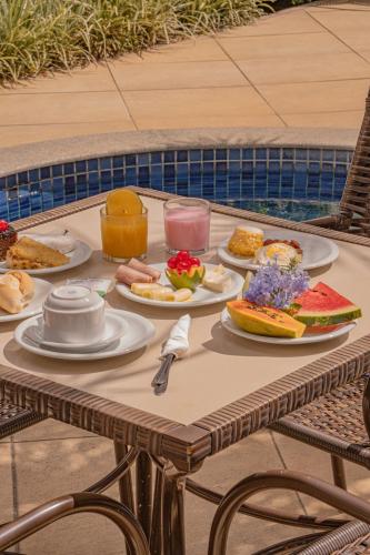a table with plates of food on it at Hotel Porto Napolis in Eunápolis