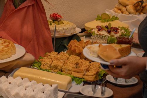 a table topped with plates of food and sandwiches at Hotel Porto Napolis in Eunápolis