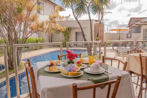 a table with food on it next to a pool at Hotel Porto Napolis in Eunápolis