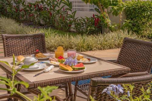 a table with plates of food on top of it at Hotel Porto Napolis in Eunápolis