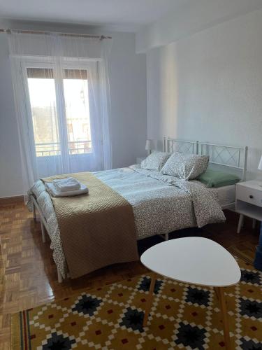 a bedroom with two beds and a table at La consulta de Paloma, Plaza encanto historico in Riaza