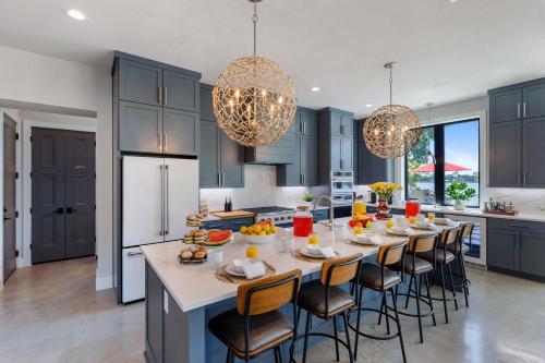 a kitchen with blue cabinets and a large table with chairs at Endless Sunset with Concierge Services in Marble Falls