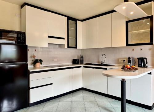 a kitchen with white cabinets and a black refrigerator at Antler Apartment in Santa Fosca