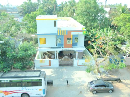 a bus is parked in front of a house at JMS Brahmin Guest House Thirunallar in Thirunallar