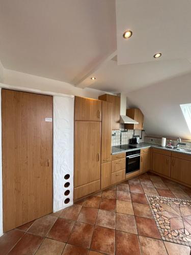 a kitchen with wooden cabinets and a tile floor at APARTMENTS RATZERSDORFER SEEN in 3100 SANKT PÖLTEN in Sankt Pölten