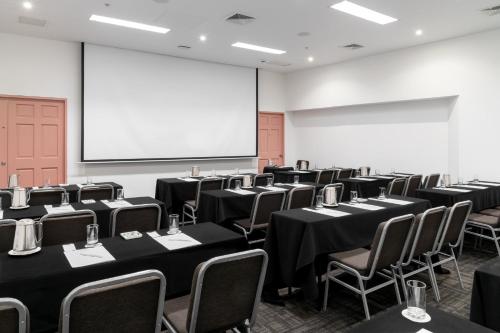 a conference room with tables and chairs and a screen at Crowne Plaza Lima by IHG in Lima
