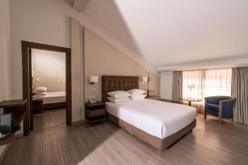 a bedroom with a bed and a desk and a mirror at InterContinental Mzaar Lebanon Mountain Resort & Spa by IHG in Kfardebian
