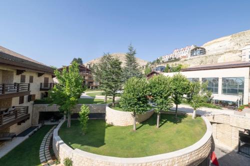 a view of a courtyard with trees and buildings at InterContinental Mzaar Lebanon Mountain Resort & Spa by IHG in Kfardebian