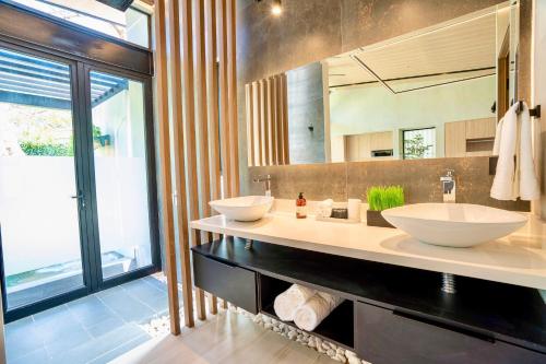 a bathroom with two sinks and a large mirror at Epic Tamarindo Boutique Hotel in Tamarindo