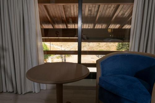 a room with a table and a blue chair and a window at InterContinental Mzaar Lebanon Mountain Resort & Spa by IHG in Kfardebian