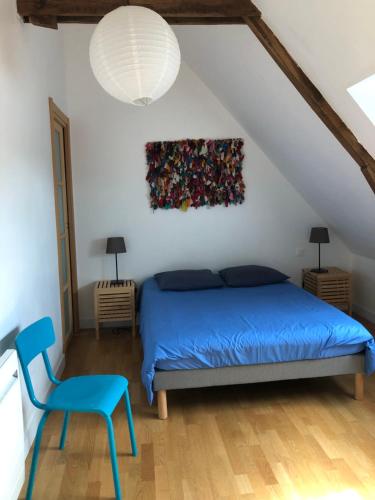 a bedroom with a blue bed and a painting on the wall at Le Tertre de la Nouette in La Bosse-de-Bretagne