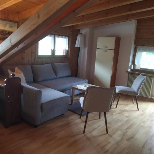 a living room with a couch and a table and chairs at Residence La Pineta in Padola