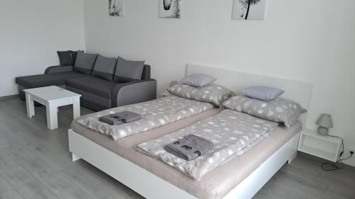 a bedroom with a bed and a couch at White Harmony Apartment in Debrecen