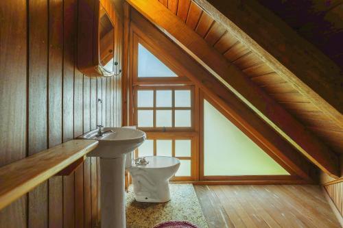 a bathroom with a sink and a toilet in a attic at Villa Bali Casas pé na areia in Barra de Ibiraquera