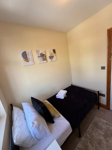 a bedroom with a bed with black sheets and pillows at Charming Stay House in Ealing