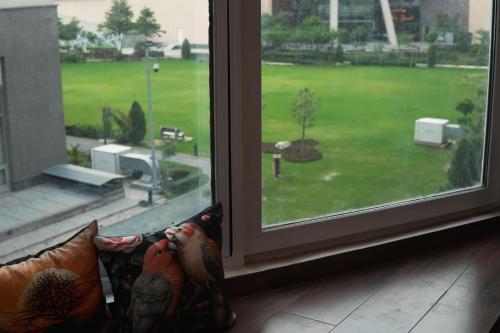 a window with a view of a green yard at Penta Square Executive City View Apartments DHA - Phase 5 Lahore in Lahore