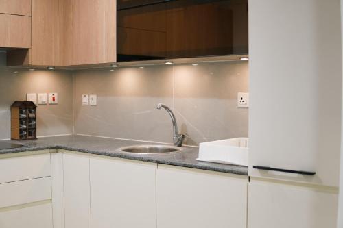 a kitchen with white cabinets and a sink at Penta Square Executive City View Apartments DHA - Phase 5 Lahore in Lahore