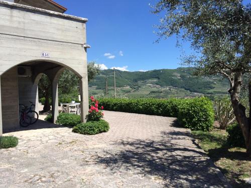 a building with an arch with a table and flowers at Valpolicella Hills in Negrar