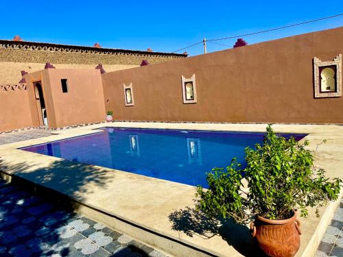 a swimming pool in front of a house at Dar Hassi Labied Merzouga in Hassilabied