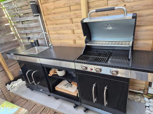 un barbecue avec un évier et un évier dans l'établissement Magnifique appartement 2 chambres avec 50 m2 de jardin privatif, à La Crau