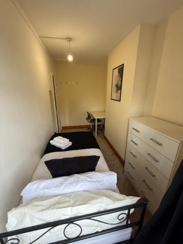 a small bedroom with a bed and a desk at Charming Stay House in Ealing